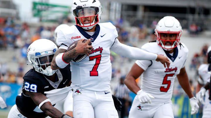 Liberty quarterback Kaidon Salter (7) runs the ball into the end zone for a touchdown as Middle Tennessee cornerback Tyrell Raby (29) tries to stop him and Liberty wide receiver Elijah Canion (5) looks on during the Salute to Veterans & Armed Forces game at MTSU on Saturday, Nov. 9, 2024.