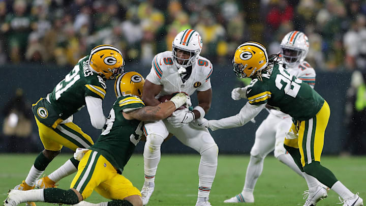 Nov 28, 2024; Green Bay, Wisconsin, USA; Green Bay Packers cornerback Eric Stokes (21),  linebacker Isaiah McDuffie (58) and safety Xavier McKinney (29) tackle Miami Dolphins tight end Jonnu Smith (9)   at Lambeau Field. Mandatory Credit: Wm. Glasheen-Imagn Images