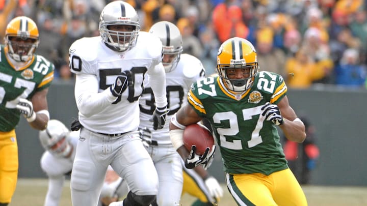 Dec 9, 2007; Green Bay, WI, USA; Will Blackmon of the Green Bay Packers (27) eludes Isaiah Ekejiuba of the Oakland Raiders (50) to score on a 57-yard punt return in the second quarter of the 38-7 victory at Lambeau Field. Mandatory Credit: Kirby Lee/Image of Sport-Imagn Images