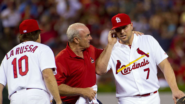 August 22, 2011; St. Louis, MO, USA; St. Louis Cardinals left fielder Matt Holliday (7) is helped off of the field by Cardinals trainer Barry Weinberg (center) after having a bug fly into his ear during the game against the Los Angeles Dodgers at Busch Stadium. The Dodgers defeated the Cardinals 2-1. Mandatory Credit: Scott Rovak-Imagn Images