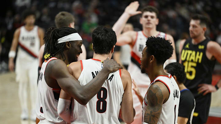 Oct 18, 2024; Portland, Oregon, USA; Portland Trail Blazers forward Deni Avdija (8) is helped up during the second half by teammates Portland Trail Blazers forward Jerami Grant (9), left, and guard Anfernee Simons (1) against the Utah Jazz at Moda Center. Mandatory Credit: Troy Wayrynen-Imagn Images