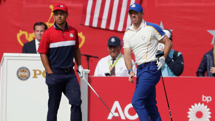 Xander Schauffele, left watches where Rory McIlroy's tee shot from the first hole went at the Ryder