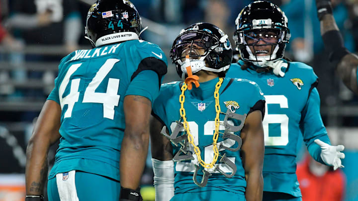 Jacksonville Jaguars cornerback Tyson Campbell (32) celebrates with teammates and a DUVAL chain.