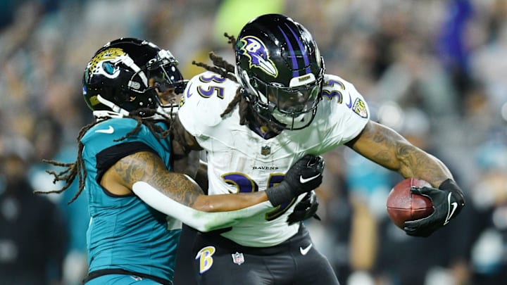 Baltimore Ravens running back Gus Edwards (35) drags Jacksonville Jaguars safety Rayshawn Jenkins