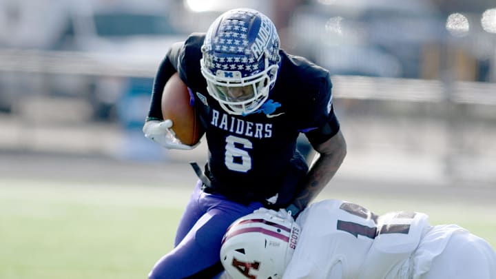 Mount Union wide receiver Wayne Ruby runs the ball for a first down under pressure from Alma