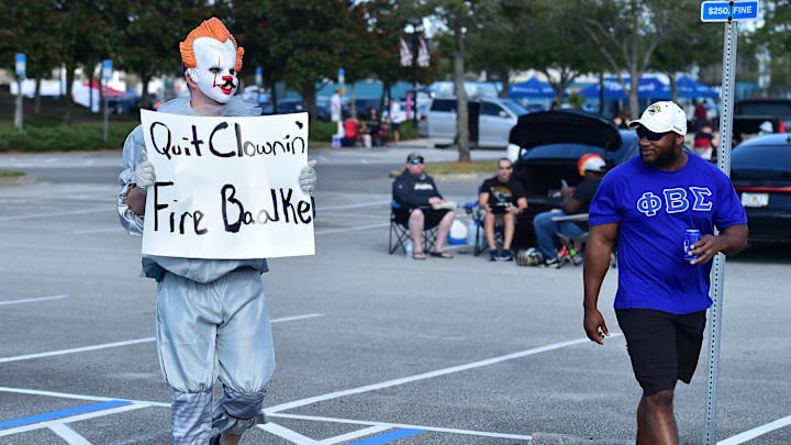 Jaguar fan Billy Vail in clown attire heads to the stadium ahead of Sunday's game against the Colts. Fans upset over team owner Shad Khan's decision to retain the team's general manager Trent Baalke after the firing of head coach Urban Meyer were encouraged to show up in clown costumes. Jaguar fan Billy Vail in clown attire heads to the stadium ahead of Sunday's game against the Colts. Fans upset over team owner Shad Khan's decision to retain the team's general manager Trent Baalke after the firing of head coach Urban Meyer were encouraged to show up in clown costumes.
