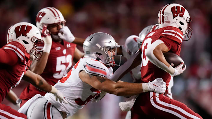 Oct 28, 2023; Madison, Wisconsin, USA; Ohio State Buckeyes linebacker Gabe Powers (36) tackles Wisconsin Badgers wide receiver Chimere Dike (13) during the NCAA football game at Camp Randall Stadium.