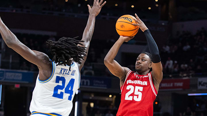 Mar 14, 2025; Indianapolis, IN, USA; Wisconsin Badgers guard John Blackwell (25) shoots the ball while UCLA Bruins forward William Kyle III (24) defends in the second half at Gainbridge Fieldhouse. Mandatory Credit: Trevor Ruszkowski-Imagn Images