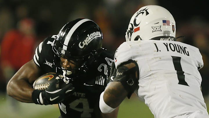 Iowa State Cyclones running back Abu Sama III (24) battles for a few yards as getting tackle by Cincinnati Bearcats' cornerback Jordan Young (1) during the fourth quarter in the week-12 NCAA football at Jack Trice Stadium on Saturday, Nov. 16, 2024, in Ames, Iowa.