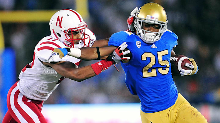 September 8, 2012; Pasadena, CA, USA; UCLA Bruins wide receiver Damien Thigpen (25) runs the ball against the defense of Nebraska Cornhuskers cornerback Ciante Evans (17) during the second half at the Rose Bowl. Mandatory Credit: Gary A. Vasquez-Imagn Images