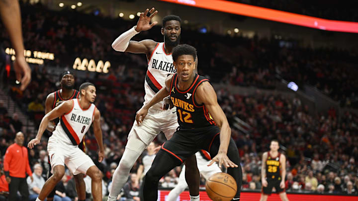 Mar 13, 2024; Portland, Oregon, USA; Atlanta Hawks forward De'Andre Hunter (12) dribbles the basketball during the second half against Portland Trail Blazers center Deandre Ayton (2) at Moda Center. Mandatory Credit: Troy Wayrynen-Imagn Images