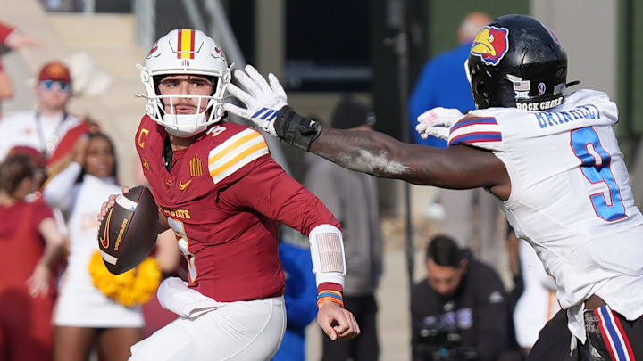 Iowa State quarterback Rocco Becht (3) looks for a pass around Kansas defensive end Dakyus Brinkley (9).