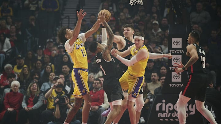 Feb 20, 2025; Portland, Oregon, USA; Portland Trail Blazers guard Anfernee Simons (1) grabs the ball away from Los Angeles Lakers center Jaxson Hayes (11) and guard Austin Reaves (15) during the first half with help from teammate center Donovan Clingan (23) at Moda Center. Mandatory Credit: Troy Wayrynen-Imagn Images