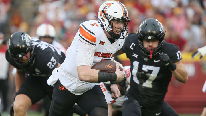 Oklahoma State Cowboys quarterback Alan Bowman (7) runs with the ball for a touchdown around Iowa State Cyclones defensive back Beau Freyler (17) and defensive back Trevon Howard (25)during the first quarter of an NCAA college football game at Jack Trice Stadium on Saturday, Sept. 23, 2023, in Ames, Iowa. Oklahoma State Cowboys quarterback Alan Bowman (7) runs with the ball for a touchdown around Iowa State Cyclones defensive back Beau Freyler (17) and defensive back Trevon Howard (25)during the first quarter of an NCAA college football game at Jack Trice Stadium on Saturday, Sept. 23, 2023, in Ames, Iowa.