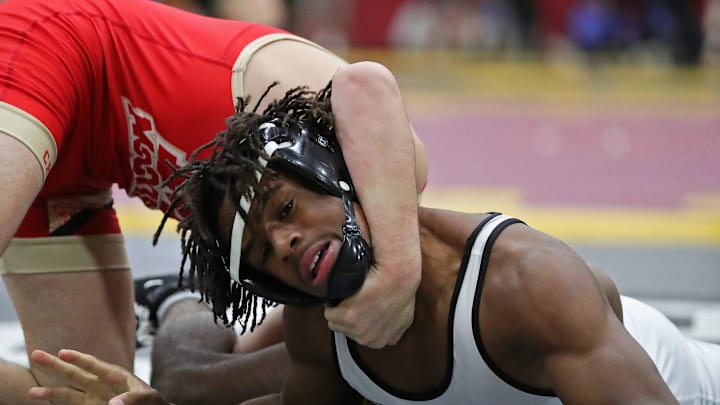 Charles Curtis of Massillon Perry struggles against Bo Bassett of Bishop McCort during their 138 pound match in the quarterfinal round of the Ironman wrestling tournament at Walsh Jesuit High School, Friday, Dec. 8, 2023, in Cuyahoga Falls, Ohio.