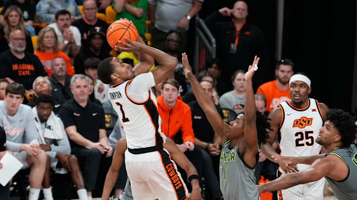 Mar 1, 2025; Waco, Texas, USA;  Oklahoma State Cowboys guard Bryce Thompson (1) scores a basket over Baylor Bears guard Robert Wright III (1) during the second half at Paul and Alejandra Foster Pavilion. Mandatory Credit: Chris Jones-Imagn Images