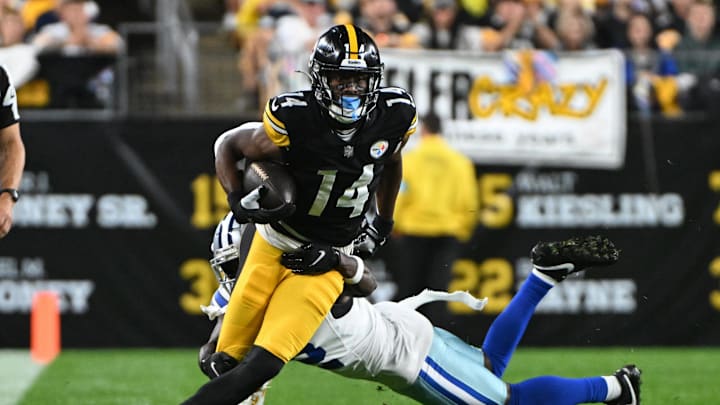Oct 6, 2024; Pittsburgh, Pennsylvania, USA; Pittsburgh Steelers wide receiver George Pickens (14) breaks a tackle by Dallas Cowboys cornerback Jourdan Lewis (2) during the first quarter at Acrisure Stadium. Mandatory Credit: Barry Reeger-Imagn Images





