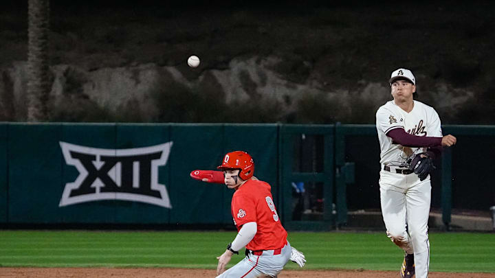 Matt King (2) of the Arizona State Sun Devils goes for a double play, throwing to first, over Matthew Graveline (9) of the Ohio State Buckeyes during ASU’s home opener at Phoenix Municipal Stadium Feb. 14, 2025, in Phoenix, Ariz.