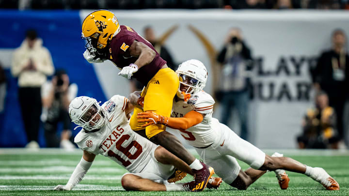Texas Longhorns defensive backs Malik Muhammad (5) and Michael Taaffe (16) work together to bring down Arizona State Sun Devils wide receiver Melquan Stovall (5) in the fourth quarter as the Texas Longhorns play the Arizona State Sun Devils in the Peach Bowl College Football Playoff quarterfinal at Mercedes-Benz Stadium in Atlanta, Georgia, Jan. 1, 2025.