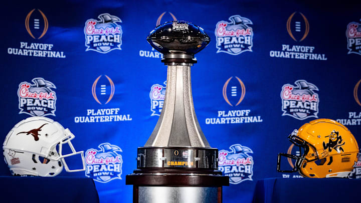 The Peach Bowl trophy is displayed next to the Texas Longhorns and Arizona State Sun Devils helmets during the Joint Head Coaches Press Conference at the Westin Peachtree Plaza in Atlanta, Georgia on Dec. 31, 2024, ahead of the Peach Bowl College Football Quarterfinal Game on New Years Day. Texas Longhorns Head Coach Steve Sarkisian joined Arizona Sun Devils Head Coach Kenny Dillingham at the press conference.