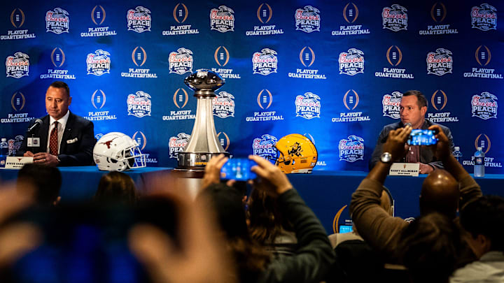 Media members take cellphone photos and video of Texas Longhorns head coach Steve Sarkisian, left, and Arizona Sun Devils head coach Kenny Dillingham as they sit down for the Joint Head Coaches Press Conference at the Westin Peachtree Plaza in Atlanta, Georgia on Dec. 31, 2024, ahead of the Peach Bowl College Football Quarterfinal Game on New Years Day.