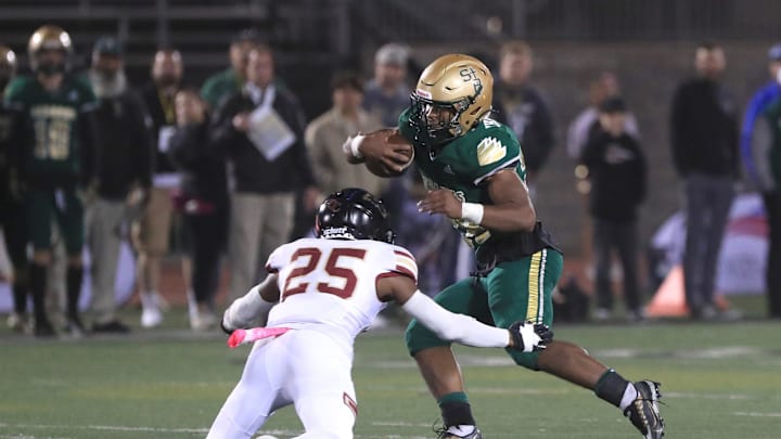 St. Bonaventure's Delon Thompson looks for an opening as Oaks Christian's Davon Benjamin tries for the tackle during the first quarter of their Marmonte League game at Ventura College on Thursday, Oct. 27, 2022. St. Bonaventure won 40-28 to earn the league championship.