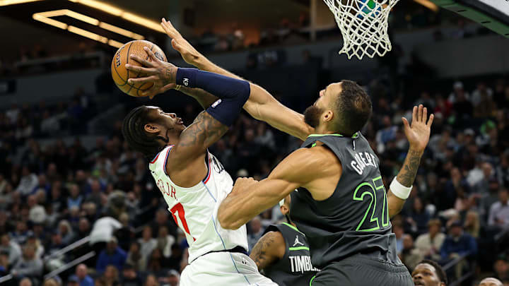 Nov 29, 2024; Minneapolis, Minnesota, USA; LA Clippers guard Kevin Porter Jr. (77) shoots as Minnesota Timberwolves center Rudy Gobert (27) defends during the second quarter of an NBA Cup game at Target Center.