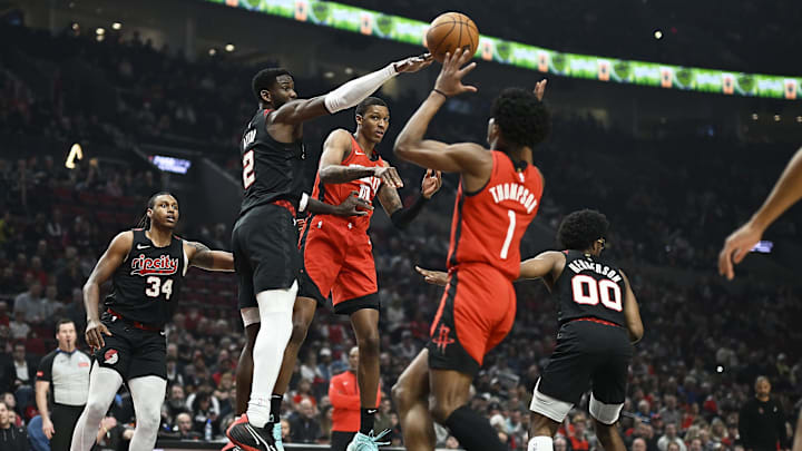 Apr 12, 2024; Portland, Oregon, USA; Houston Rockets forward Jabari Smith Jr. (10) passes the ball during the first half to forward Amen Thompson (1) against Portland Trail Blazers center Deandre Ayton (2) at Moda Center. Mandatory Credit: Troy Wayrynen-Imagn Images