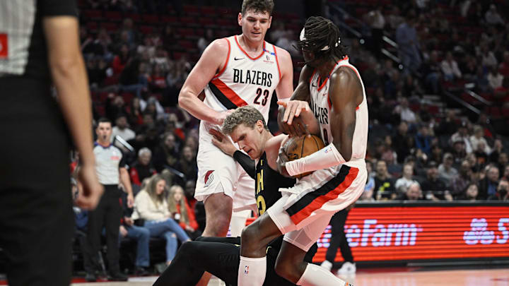 Oct 18, 2024; Portland, Oregon, USA; Portland Trail Blazers forward Jerami Grant (9) blocks a shot during the first half against Utah Jazz forward Lauri Markkanen (23) with help from center Donovan Clingan (23) at Moda Center. Mandatory Credit: Troy Wayrynen-Imagn Images