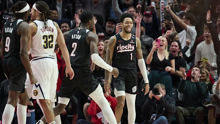 Dec 19, 2024; Portland, Oregon, USA; Portland Trail Blazers guard Anfernee Simons (1) celebrates with center Deandre Ayton (2) after scoring the game winning shot against the Denver Nuggets at Moda Center. Mandatory Credit: Troy Wayrynen-Imagn Images