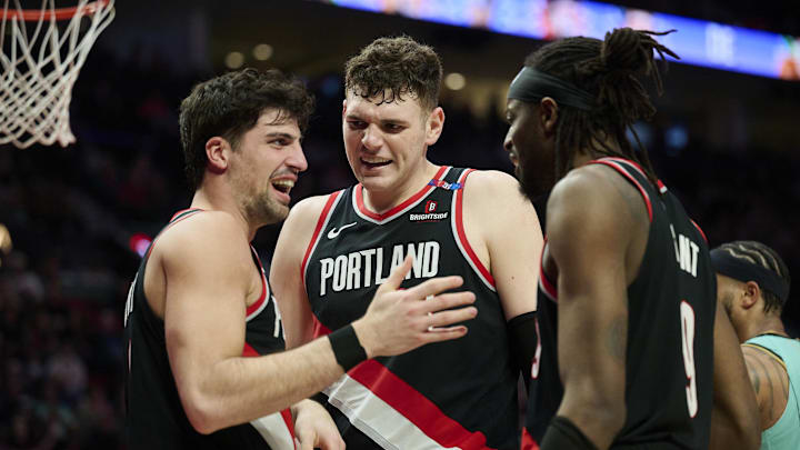 Feb 22, 2025; Portland, Oregon, USA; Portland Trail Blazers center Donovan Clingan (23) and forward Jerami Grant (9) celebrate with forward Deni Avdija (8) during the second half against the Charlotte Hornets at Moda Center. Mandatory Credit: Troy Wayrynen-Imagn Images