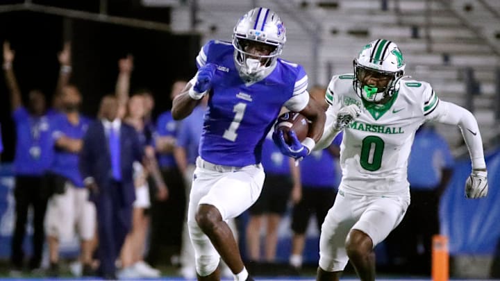 Middle Tennessee wide receiver Nahzae Cox (1) carries the ball down the field as Marshall defensive back Cam Smith (0) tries to catch him during MTSU's Homecoming football game against Marshall on Saturday, Sept. 20, 2025.