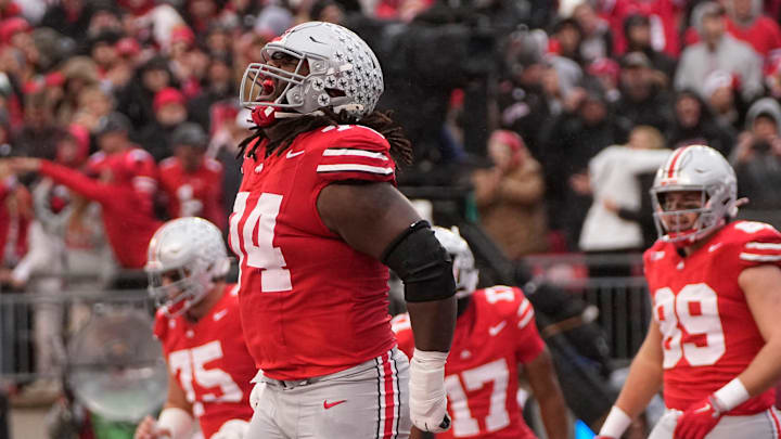 Ohio State Buckeyes offensive lineman Donovan Jackson (74) celebrates a touchdown by running back TreVeyon Henderson (32) during the first half of the NCAA football game against the Indiana Hoosiers at Ohio Stadium in Columbus on Saturday, Nov. 23, 2024.