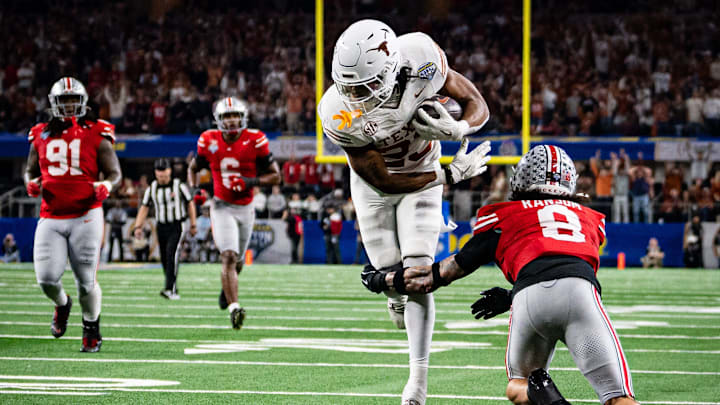 Texas Longhorns running back Jaydon Blue runs around defense from Ohio State Buckeyes safety Lathan Ransom.