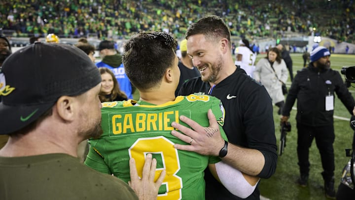 Nov 9, 2024; Eugene, Oregon, USA; Oregon Ducks head coach Dan Lanning celebrates with quarterback Dillon Gabriel (8) after beating the Maryland Terrapins at Autzen Stadium. Mandatory Credit: Troy Wayrynen-Imagn Images