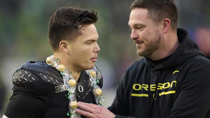 Nov 30, 2024; Eugene, Oregon, USA; Oregon Ducks head coach Dan Lanning celebrates with quarterback Dillon Gabriel (8) during a senior recognizing ceremony before a game against the Washington Huskies at Autzen Stadium. Mandatory Credit: Troy Wayrynen-Imagn Images