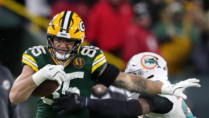 Green Bay Packers tight end Tucker Kraft (85) makes a catch against the defense of Miami Dolphins linebacker Jordyn Brooks (20) in the first half football game at Lambeau Field.  