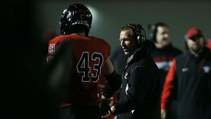 Gilbert's  Will Hawthorne (43) celebrates with head coach Graham Lundt after a touchdown during a playoff win last week.