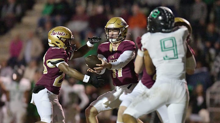 St. Augustine's Locklan Hewlett (11) hands off to Trendell Anderson (23) on a play that had Anderson run into the end zone for a late first quarter touchdown. The Choctawhatchee Indians traveled to Saint Augustine High School to take on the Yellow Jackets in the FHSAA Region 1-3A High School Football Finals Friday, November 24, 2023. The Yellow Jackets led 21 to 17 at the half.