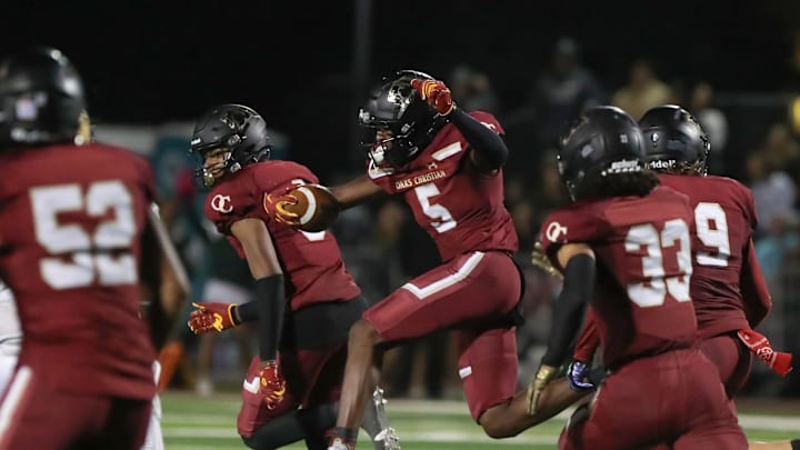 Oaks Christian's Davon Benjamin leaps through an opening after making an interception of a St. Bonaventure pass during the third quarter of the Marmonte League title game on Friday, Oct. 27, 2023, at Oak Christian's Thorson Stadium. Oaks Christian won 13-10.