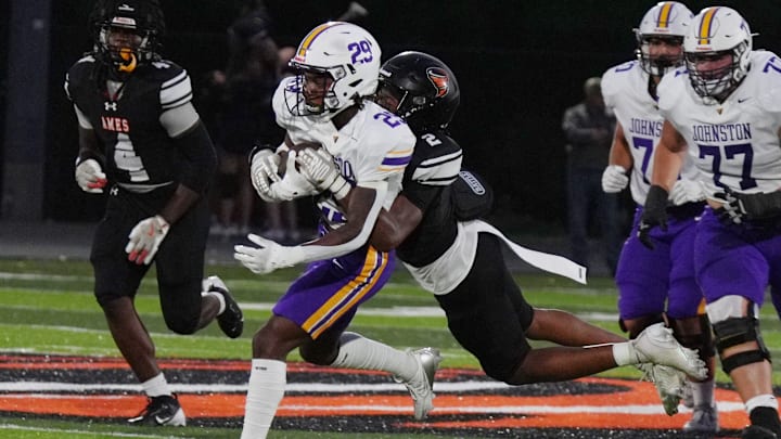 Johnston's running back Jeremiah Armstrong (29) gets tackle Ames’ defender Torian Cotton (2) as running for a first down during the second quarter at Ames High Football field on, Sept 12, 2025, in Ames, Iowa