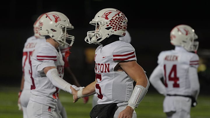 Newton Cardinals quarterback/defensive back Caden Klein (5) gets congratulation by team mates after winning against Gilbert in the high school football class 4A quarterfinal on Nov. 7, 2025, at Tigers Stadium, Gilbert, Iowa.