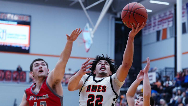 Ames guard Will Thomas (22) shoots the ball between Ottumwa's center Charlie Morgan (42) and Ethan Gravett (20) during the the first quarter in the high school boys basketball at Ames High’s Harrison Barnes Gymnasium on Feb. 13, 2026, in Ames, Iowa.