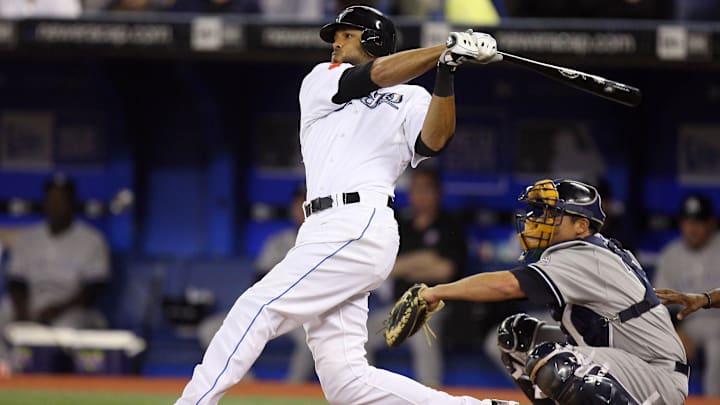 Former Toronto Blue Jays player Alex Rios swings the bat wearing a white jersey and black helmet. Former Toronto Blue Jays player Alex Rios swings the bat wearing a white jersey and black helmet.