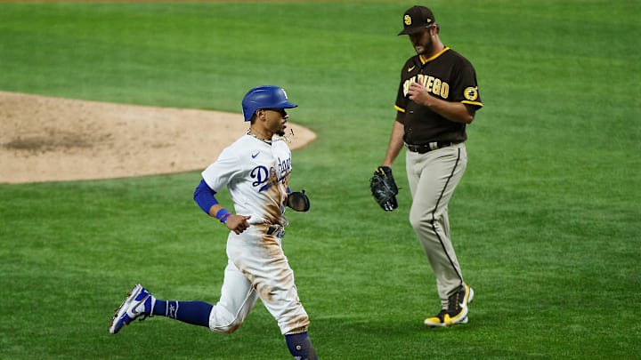 Oct 7, 2020; Arlington, Texas, USA; Los Angeles Dodgers right fielder Mookie Betts (50) runs past San Diego Padres relief pitcher Drew Pomeranz (15) as he scores on a sacrificer fly by third baseman Justin Turner (not pictured) during the seventh inning in game two of the 2020 NLDS at Globe Life Field. Mandatory Credit: Tim Heitman-Imagn Images Oct 7, 2020; Arlington, Texas, USA; Los Angeles Dodgers right fielder Mookie Betts (50) runs past San Diego Padres relief pitcher Drew Pomeranz (15) as he scores on a sacrificer fly by third baseman Justin Turner (not pictured) during the seventh inning in game two of the 2020 NLDS at Globe Life Field. Mandatory Credit: Tim Heitman-Imagn Images
