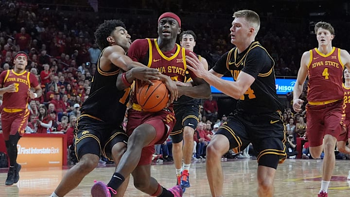 Iowa State Cyclones forward Killyan Toure (27) drives to the basket as Iowa Hawkeyes guard Kael Combs (11) and I guard Bennett Stirtz (14) defend and fouled during the second half in the men’s basketball Cy-Hawk series on Dec. 11, 2025, in Ames, Iowa.