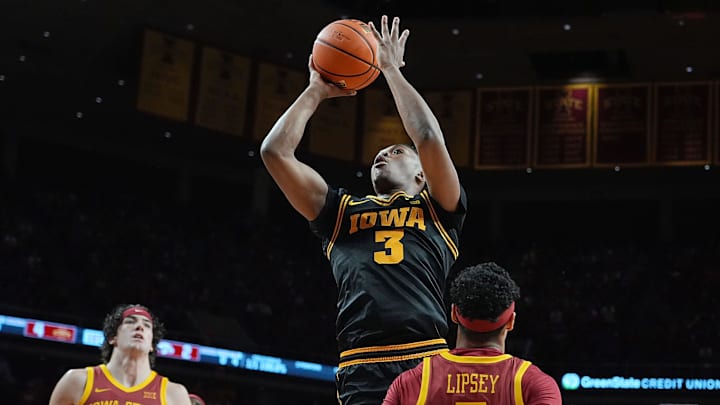 Iowa Hawkeyes forward Cam Manyawu (3) shoots the ball over between Iowa State Cyclones forward Blake Buchanan (23) and Iowa State Cyclones guard Tamin Lipsey (3) during the first half in the men’s basketball Cy-Hawk series on Dec. 11, 2025, in Ames, Iowa. Iowa Hawkeyes forward Cam Manyawu (3) shoots the ball over between Iowa State Cyclones forward Blake Buchanan (23) and Iowa State Cyclones guard Tamin Lipsey (3) during the first half in the men’s basketball Cy-Hawk series on Dec. 11, 2025, in Ames, Iowa.