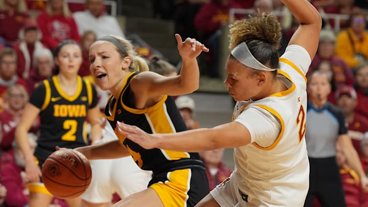 Iowa Hawkeyes guard Kylie Feuerbach (4) drives with the ball as Iowa State Cyclones' guard Arianna Jackson (2) defends during the first quarter in the NCAA women’s basketball Cy-Hawk Series on Dec. 10, 2025, at Hilton Coliseum in Ames, Iowa.