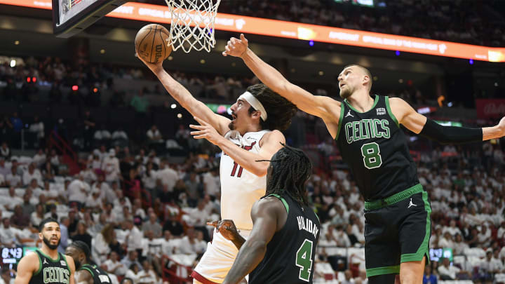 Apr 29, 2024; Miami, Florida, USA; Miami Heat guard Jaime Jaquez Jr. (11) scores in front of Boston Celtics center Kristaps Porzingis (8) during the first quarter of game four of the first round for the 2024 NBA playoffs at Kaseya Center. Mandatory Credit: Michael Laughlin-USA TODAY Sports