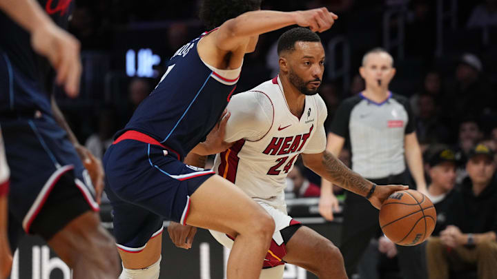 Dec 1, 2025; Miami, Florida, USA; Miami Heat guard Norman Powell (24) drives past Los Angeles Clippers guard Kobe Sanders (4) during the second half at Kaseya Center. Mandatory Credit: Jim Rassol-Imagn Images